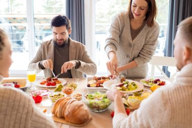 Four friends sharing a delightful meal indoors, highlighting friendship and togetherness.